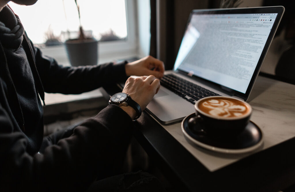 A photo of a gym owner working on a gym business plan with a coffee