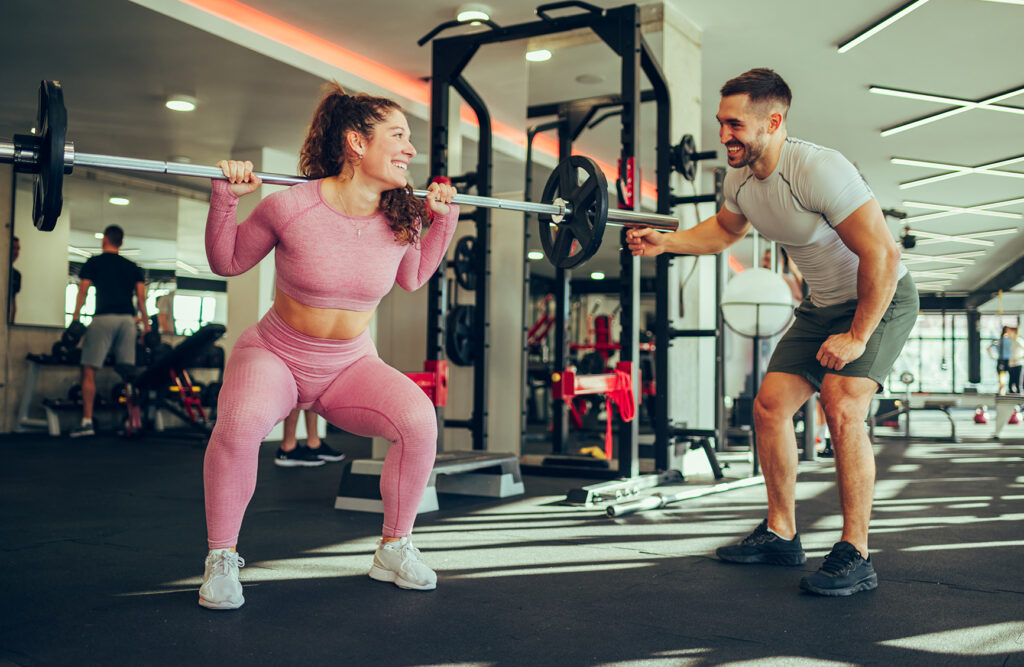 A photo of a personal trainer in the gym delivering a highly motivational session to a customer